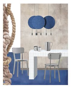 two chairs and a table in front of a wall with circles hanging from the ceiling