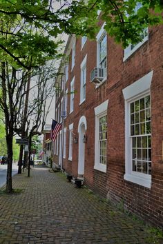 an american flag is hanging on the side of a brick building