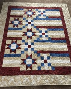 a quilted table topper with red, white and blue stars on it's border