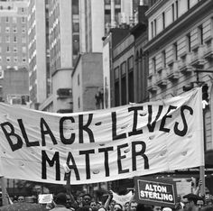 black lives matter banner being held by protesters in new york city, ny during the march revolution