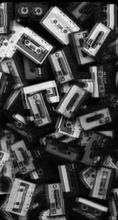 cassette tapes are piled on top of each other in this black and white photo by person