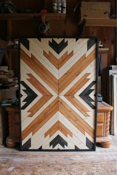 a wooden paneled wall with black and white designs on the bottom, next to a fireplace