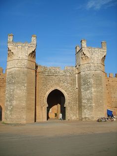 an old brick building with two towers and a gate