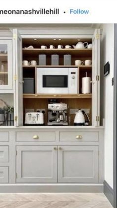 a kitchen with lots of white cabinets and appliances on it's shelves, along with an open microwave oven