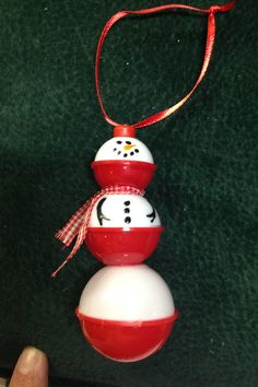 a red and white snowman ornament hanging from a string