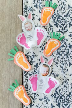 some baby feet and carrots are on the table next to a paper cutout