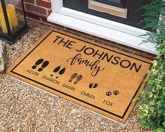 a door mat that says the johnson family with footprints and paw prints on it in front of a house