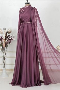 Step into elegance with this exquisite Full-Length Evening Gown. Crafted in a rich shade of deep plum, this gown features a luxurious chiffon fabric that drapes beautifully, creating a silhouette that flatters every figure. The delicate beading along the high neckline and waist adds a touch of sparkle, while the sweeping floor-length skirt ensures you make a grand entrance at any event.The intricate detailing on this gown sets it apart. A unique cross-body draping design adds depth and sophistic Pre-draped Georgette Wedding Dress, Pre-draped Georgette Evening Dress For Party, Purple Chiffon Dress For Wedding, Evening Draped Georgette Gown, Purple Chiffon Wedding Dress, Draped Georgette Evening Gown, Purple Chiffon Dress For Banquets, Chiffon Gown For Evening, Chiffon Long Evening Gown