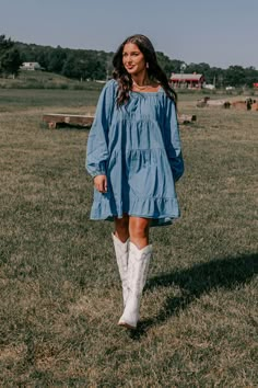 - Fall fashion is in the air with this darling dress!  - Unlined chambray material  - An elastic square cut neckline  - Long, loose sleeves with elastic cuffs  - A relaxed silhouette that ends in a ruffled mini dress length hemline Country Fall Dresses, Long Fitted Dress Casual, Dresses With Western Boots, Fall Mini Denim Dress, Fall Denim Mini Dress With Button Closure, Long Sleeve Denim Dress With Ruffles, Country Dresses With Cowboy Boots, Dress With Western Boots, Light Wash Long Sleeve Denim Mini Dress