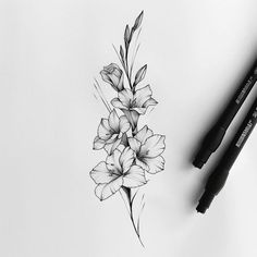 a pencil drawing of some flowers on a white paper next to two black marker pens