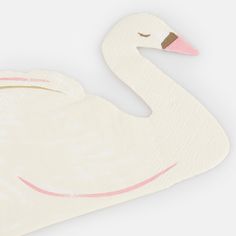 a close up of a swan shaped object on a white surface with a pink stripe