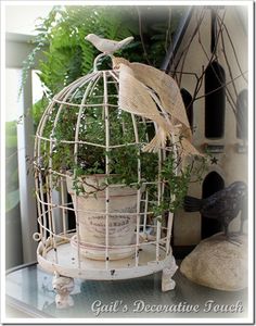 a white bird cage with plants in it