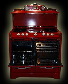 an old fashioned red stove with two ovens