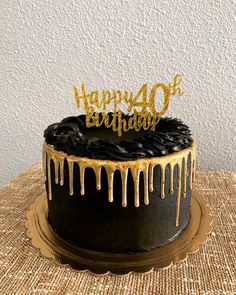 a black and gold birthday cake with dripping icing on the top that says happy 40