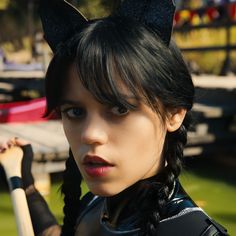 a woman with cat ears holding a baseball bat