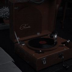 an old record player sitting on top of a suitcase