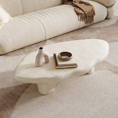 a white coffee table sitting on top of a carpeted floor next to a couch