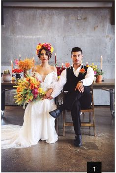 a man and woman sitting next to each other in front of a table with candles