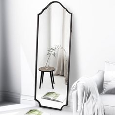 a mirror sitting on top of a white floor next to a couch