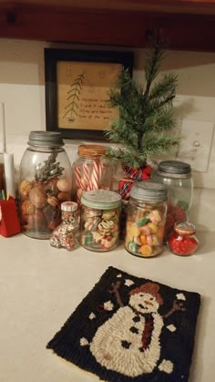 a kitchen counter with jars filled with candies, candy and other holiday treats on it