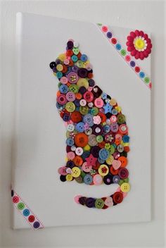 a cat made out of buttons on a white board