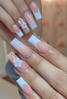 a woman's hands with pink and white manies on their nails, decorated with flowers