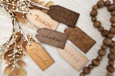 wooden name tags are laid out on a table with beads and wood bead necklaces