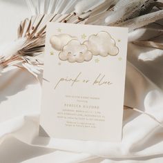 a white card with gold foil stars and clouds on it, sitting on a bed