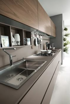 a modern kitchen with stainless steel sinks and cabinets