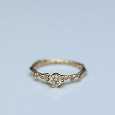 a yellow gold ring with three diamonds on it's sides, sitting on a white surface