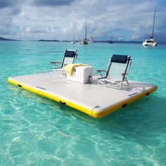 two lounge chairs sitting on top of an inflatable raft floating in the ocean