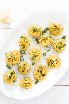 small appetizers are arranged on a white platter