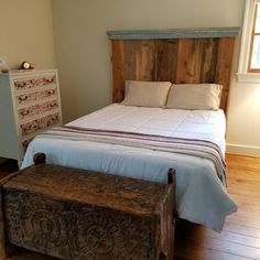 a bed with a wooden headboard and foot board next to a dresser in a bedroom