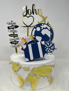 a white cake with blue and yellow decorations on it's top, along with directional signs