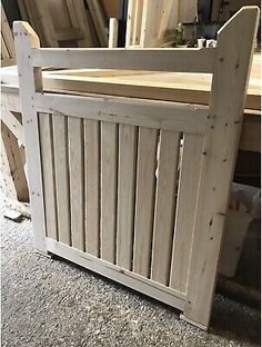 a wooden bed frame sitting on top of a floor next to a pile of wood