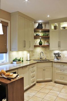 a kitchen filled with lots of white cabinets and counter top space next to a window