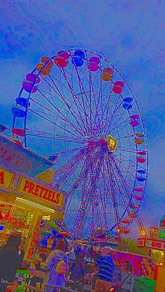 the ferris wheel is brightly lit up at night