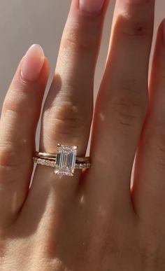 a woman's hand with an engagement ring on it