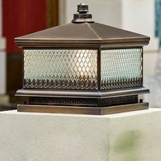 a light that is sitting on top of a wall next to a building with a red door in the background