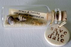 a message in a glass bottle with sea shells inside and save the date written on it