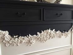 a black dresser with white flowers on it