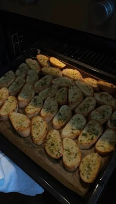 bread is being cooked in the oven with herbs on top and seasonings on the side