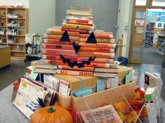 a stack of books in a library with a jack - o'- lantern on top