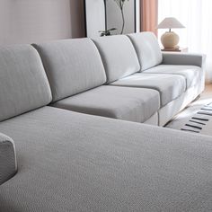 a white couch sitting next to a window in a living room