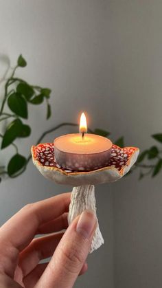 a hand holding a small candle holder