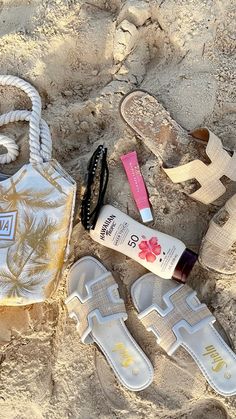 sandals, hand sanitizer and sunscreen on the sand