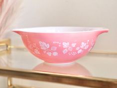 a pink bowl sitting on top of a glass table