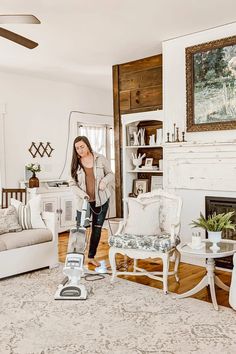 a woman is vacuuming the floor in her living room