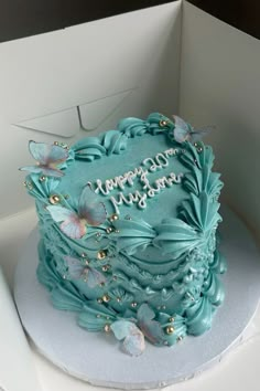 a birthday cake with blue frosting and butterflies on it