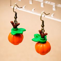 a pair of oranges with green leaves and antlers on them hanging from hooks